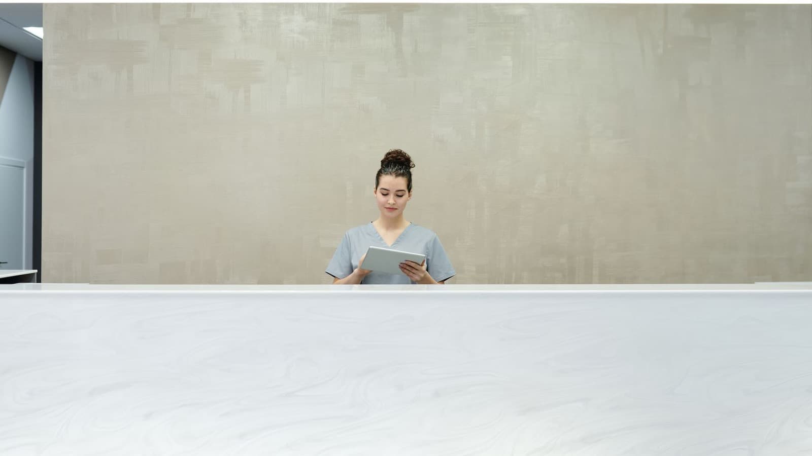 Nhân viên lễ tân sử dụng tablet để quản lý thông tin khách hàng và lịch dịch vụ