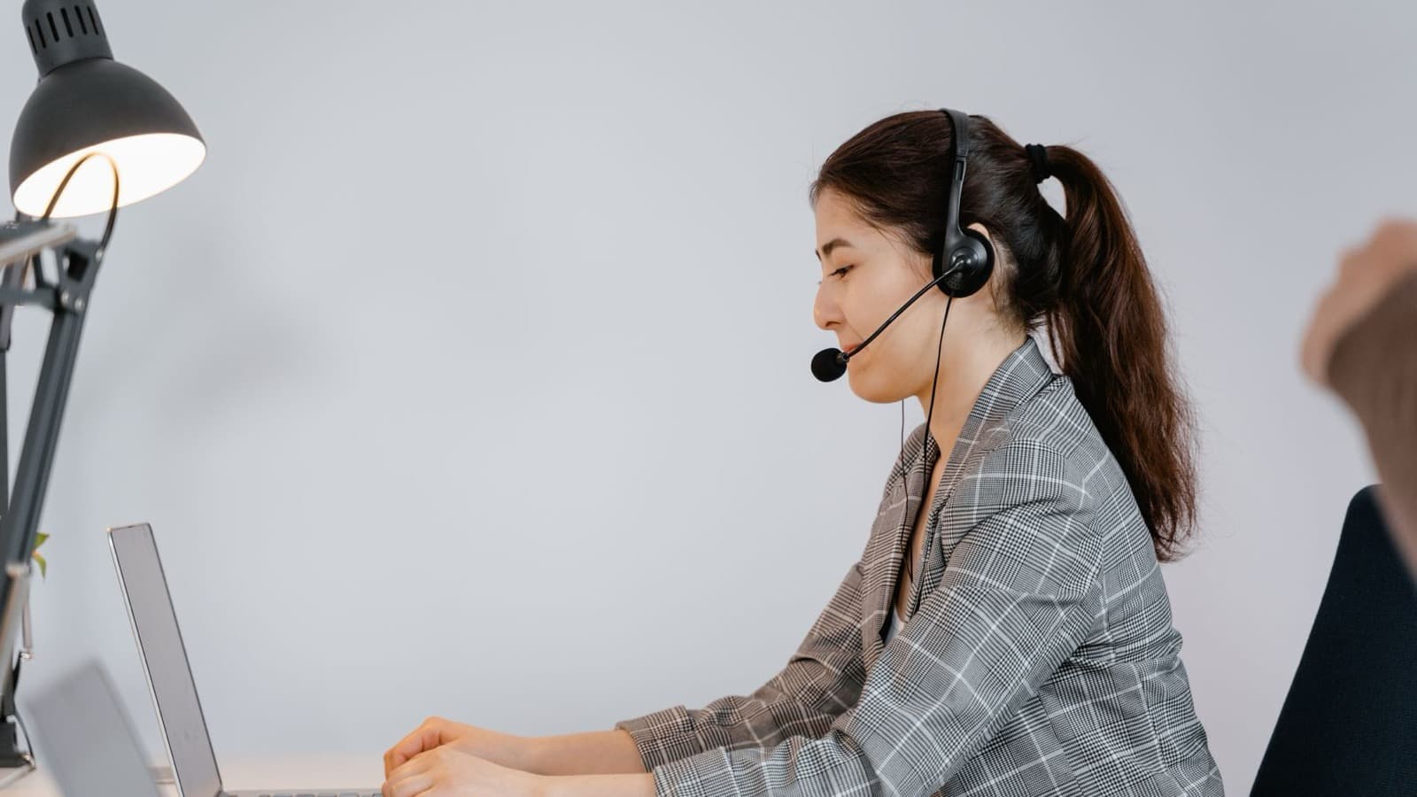 Nhân viên chăm sóc khách hàng xử lý email trên laptop trong môi trường làm việc thực tế