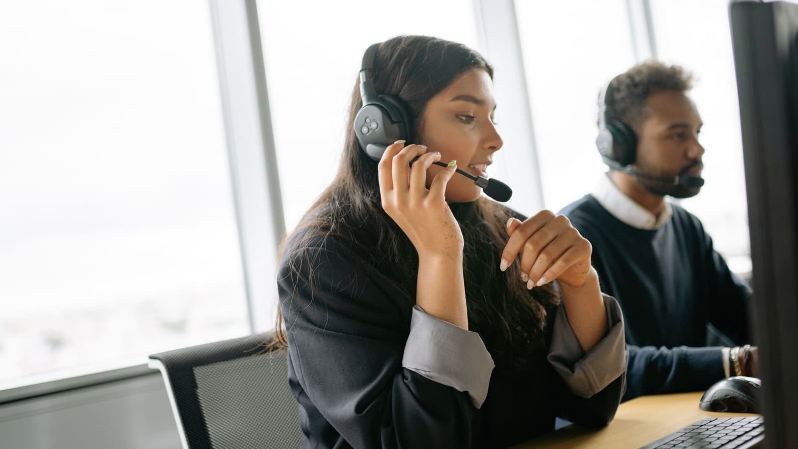 Nhân viên hỗ trợ khách hàng đeo headset trong ca trực để đo hiệu quả pilot AI receptionist