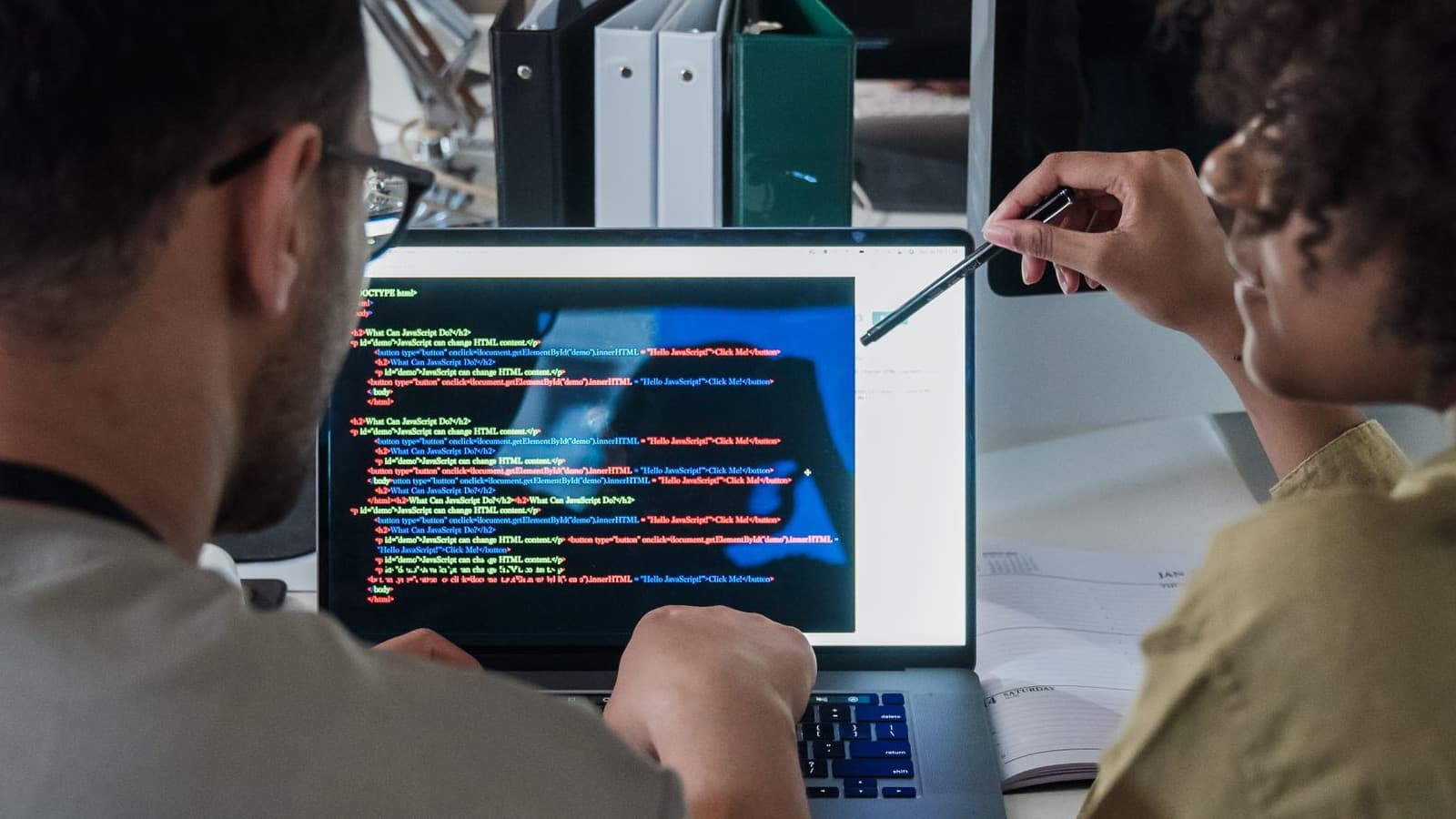 Hai lập trình viên cùng review mã nguồn khi so sánh staff augmentation và team trọn gói